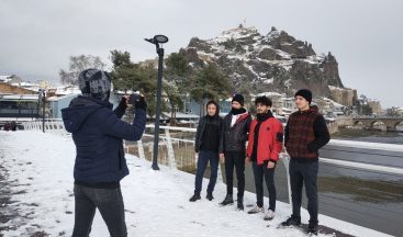 Beyaz örtüyle kaplanan tarihi kaleye karşı hatıra fotoğrafı